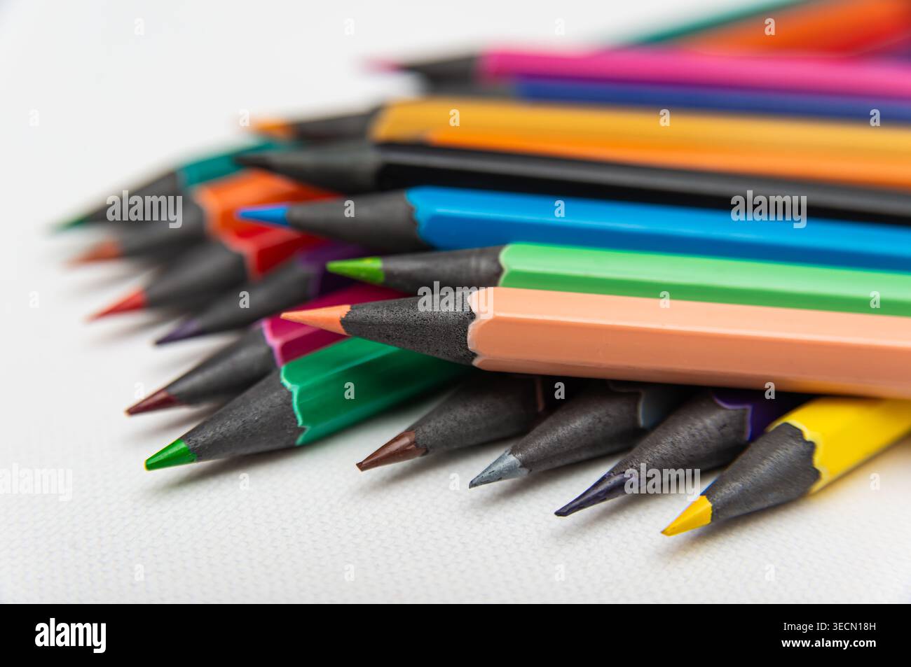 Le matite in vari colori sono posizionate su una superficie piatta pronta per l'uso in progetti artistici e attività creative. Foto Stock
