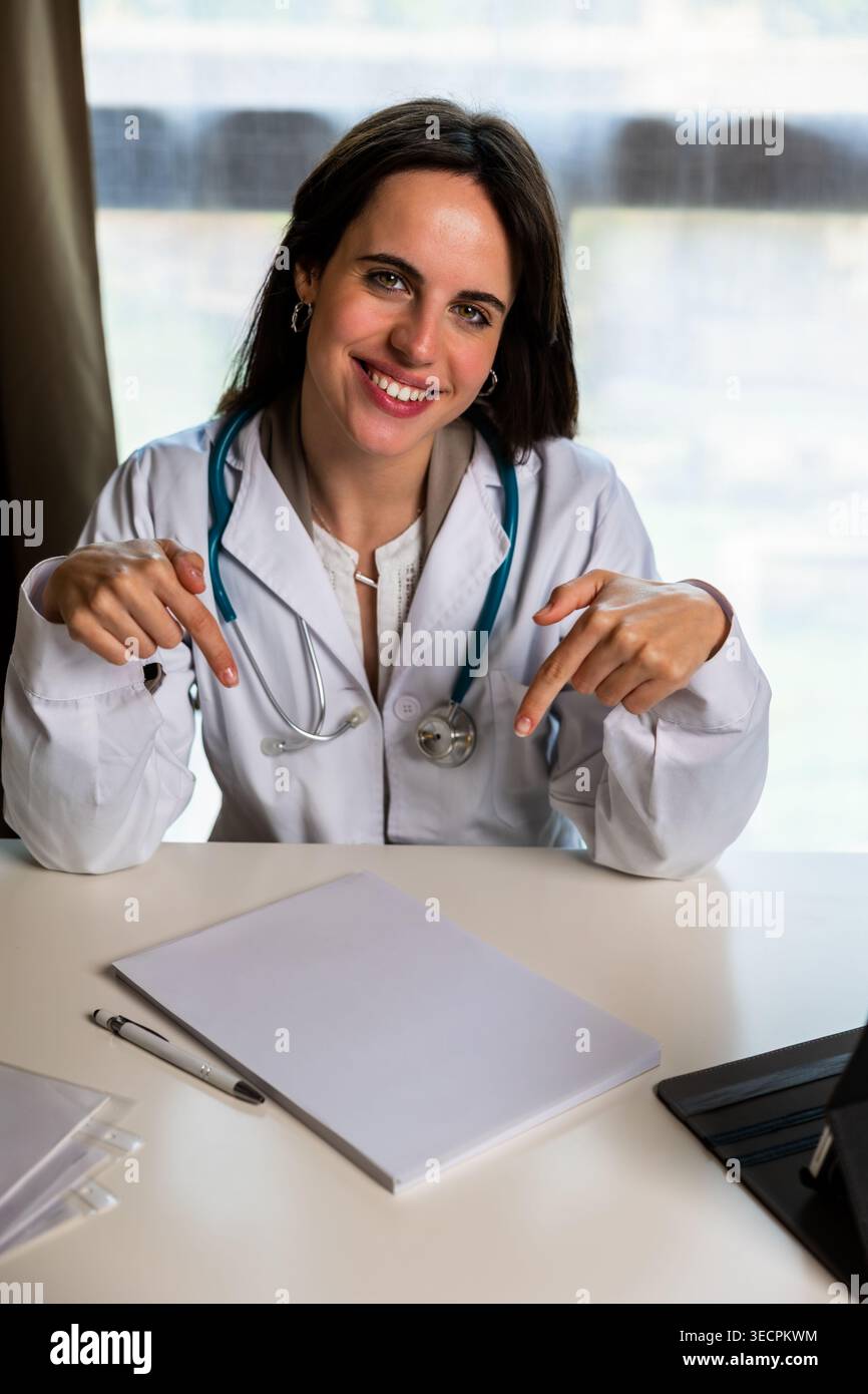 Medico donna che indica un documento vuoto Foto Stock
