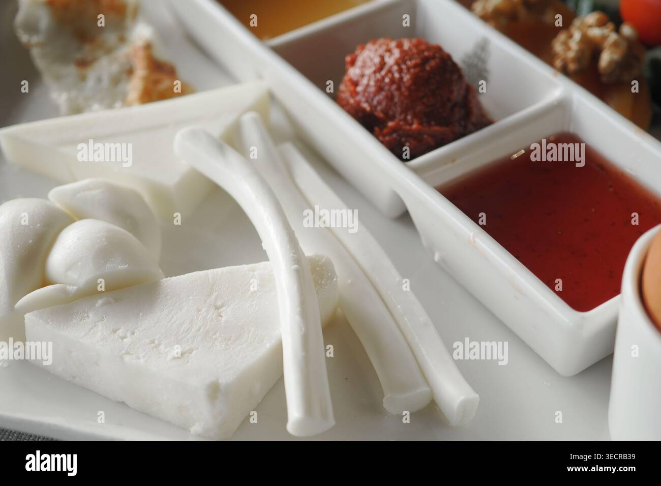 Diversi tipi di formaggio e salse su un piatto bianco Foto Stock