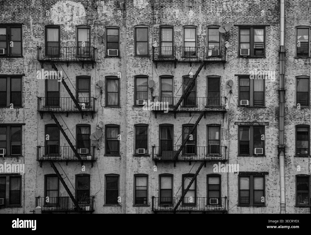 Una fotografia vintage in bianco e nero della facciata di un edificio di New York City, che mostra numerose finestre, fuochi d'incendio e l'intricata architettura, captur Foto Stock
