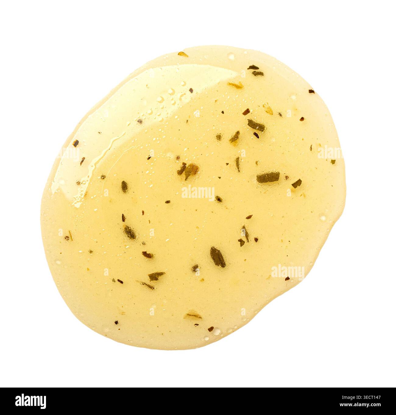 Condimento per insalata con contagocce di erbe, creando un'impasto giallo su bianco Foto Stock