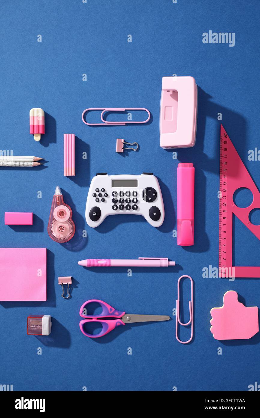 Le forniture della scuola di arte pop si trovano su sfondo blu con una calcolatrice a forma di gamepad, cancelleria rosa e conc. Gamification Gen Z di ritorno a scuola Foto Stock