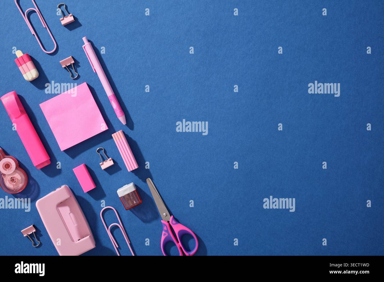 Composizione pop art di materiale scolastico rosa su sfondo blu, tra cui forbici, clip, penne e note; concetto per Back to School for Generation Foto Stock
