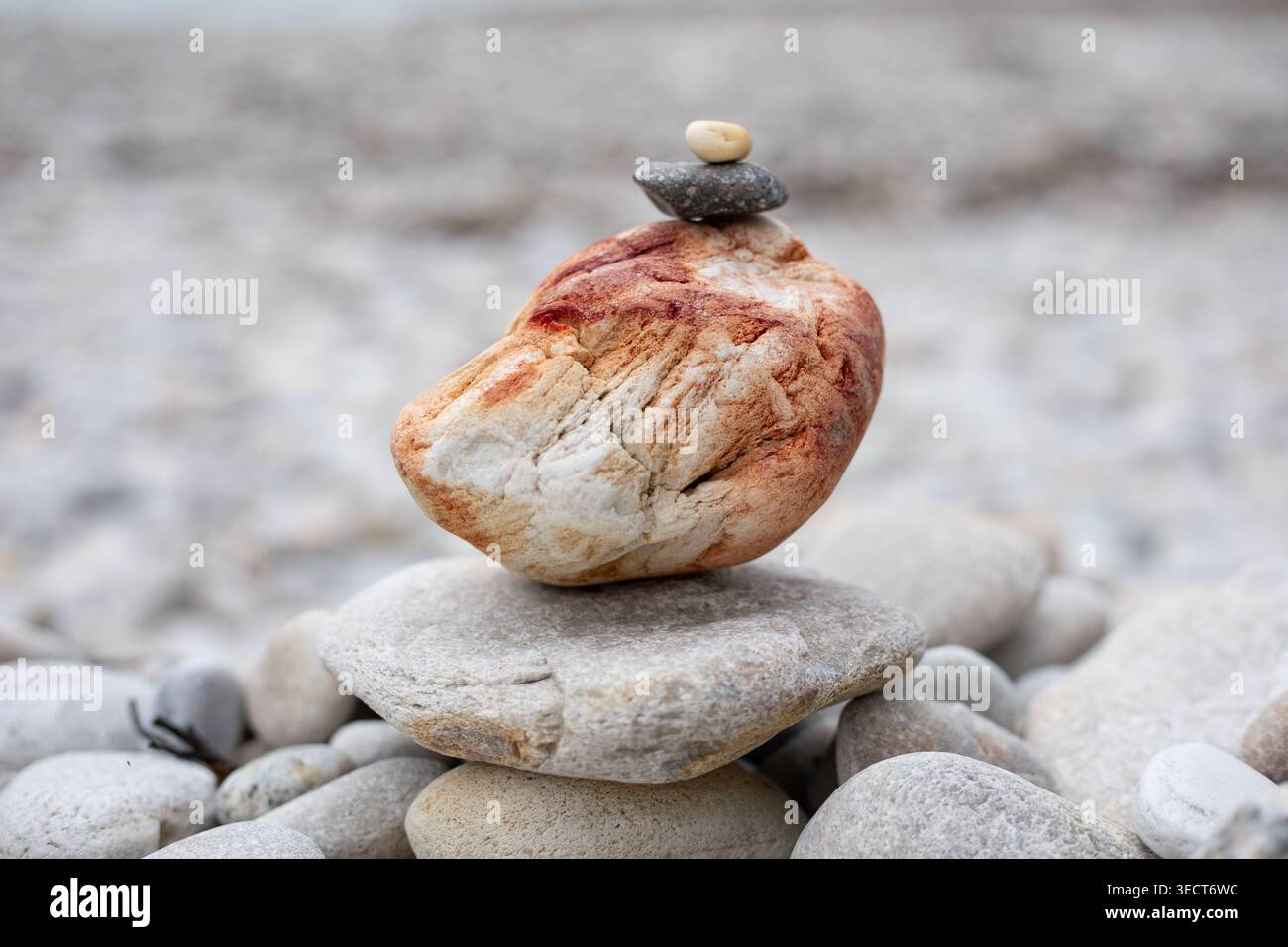 Pile di pietre bianche simili a zen sulla spiaggia che invitano calma e riflessione Foto Stock