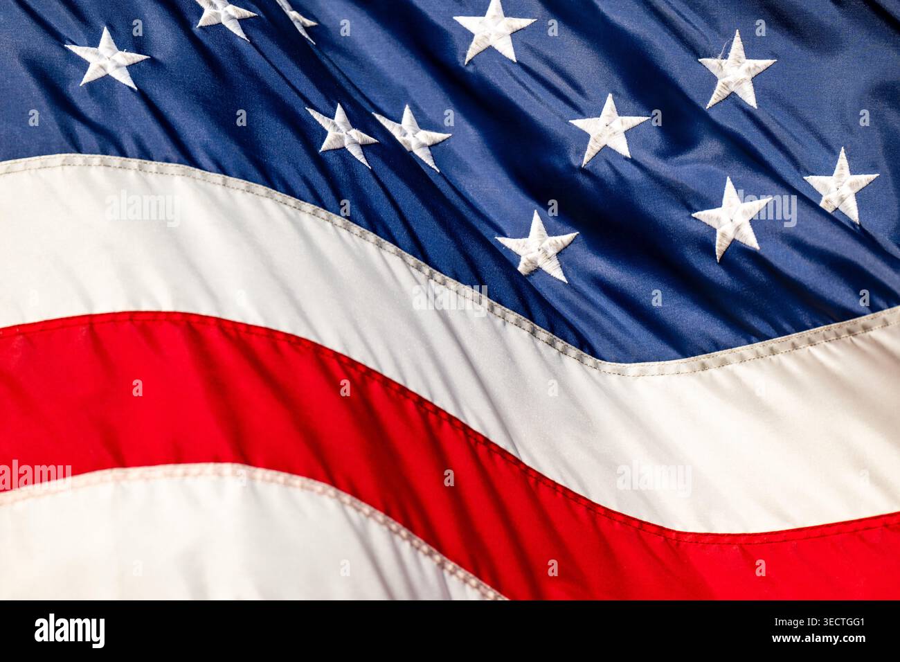 Bandiera degli Stati Uniti Stelle ricamate che sventolano a Washington DC Stati Uniti | WASHINGTON D.C., Stati Uniti — Una vista ravvicinata mostra le stelle bianche ricamate e le strisce cucite di una bandiera degli Stati Uniti che sventolano al vento. L'attuale design a 50 stelle è stato creato da Robert G. Heft e adottato nel 1960 dopo che le Hawaii si sono unite all'unione. Le specifiche federali, stabilite con l'Executive Order 10834, regolano le proporzioni esatte e i colori ufficiali noti come Old Glory Red e Old Glory Blue. Foto Stock