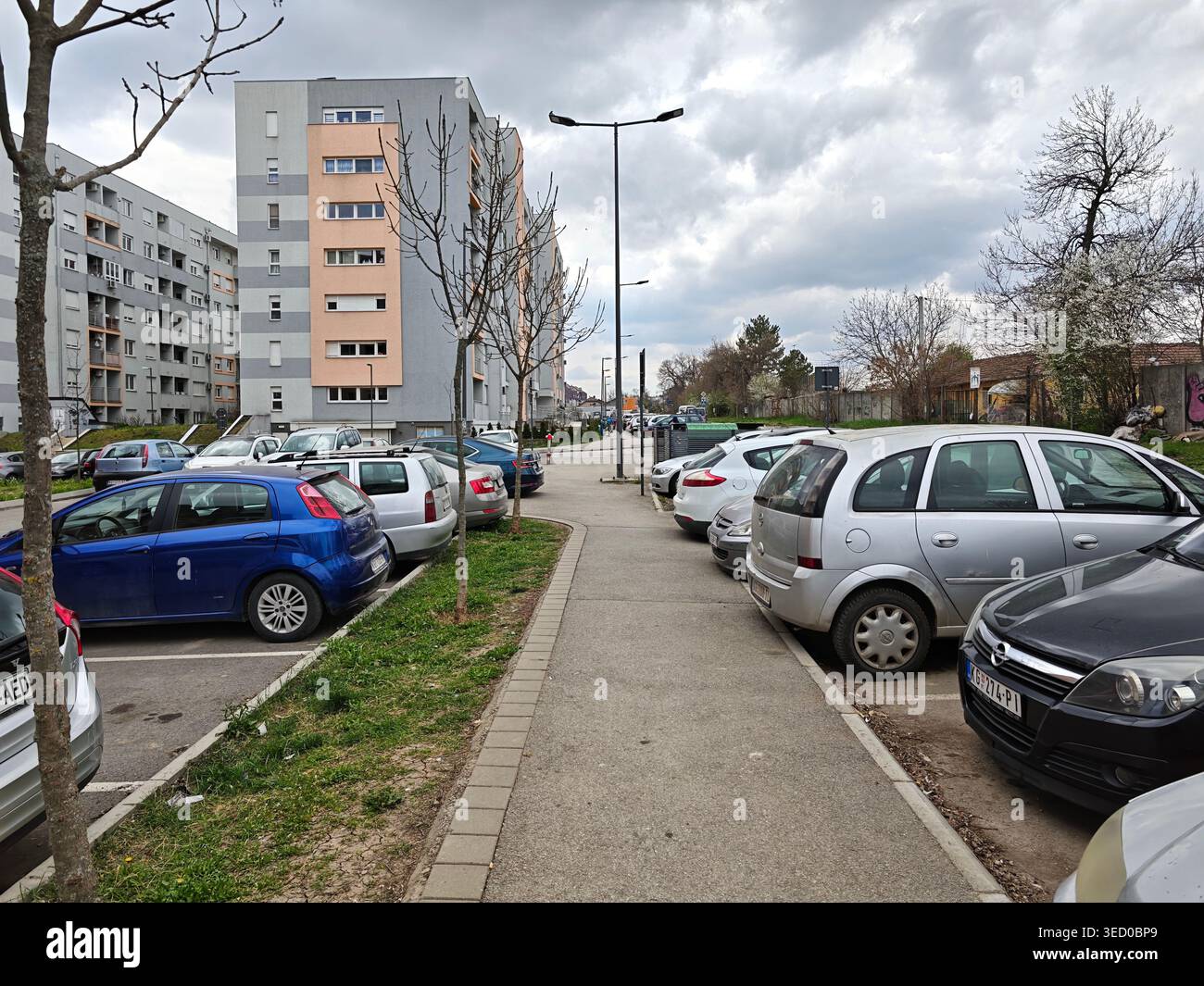 Parcheggio della strada residenziale urbana sotto il cielo nuvoloso Foto Stock
