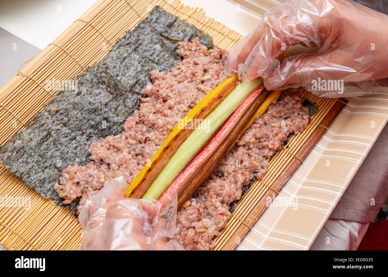 Tradizionale kimbap coreano arrotolato a mano con riso multi-grano e vari ingredienti Foto Stock