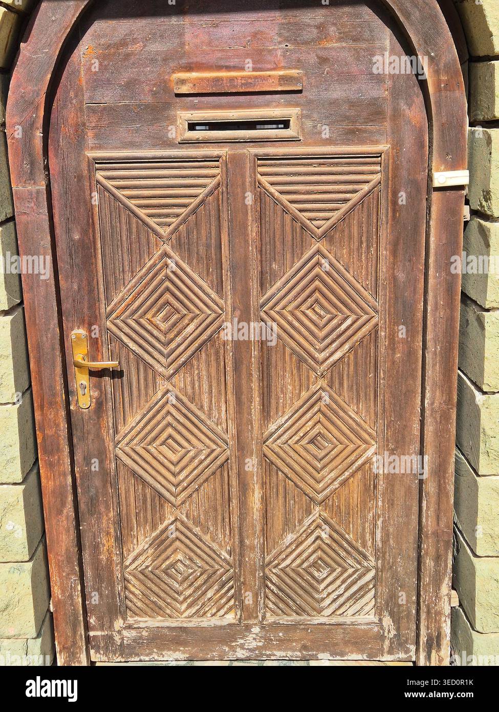 Massicce porte in legno con intagli geometrici spesso a forma di diamanti sono una caratteristica del risveglio bulgaro e dell'arco tradizionale - Immagine stock catturata con smartphone