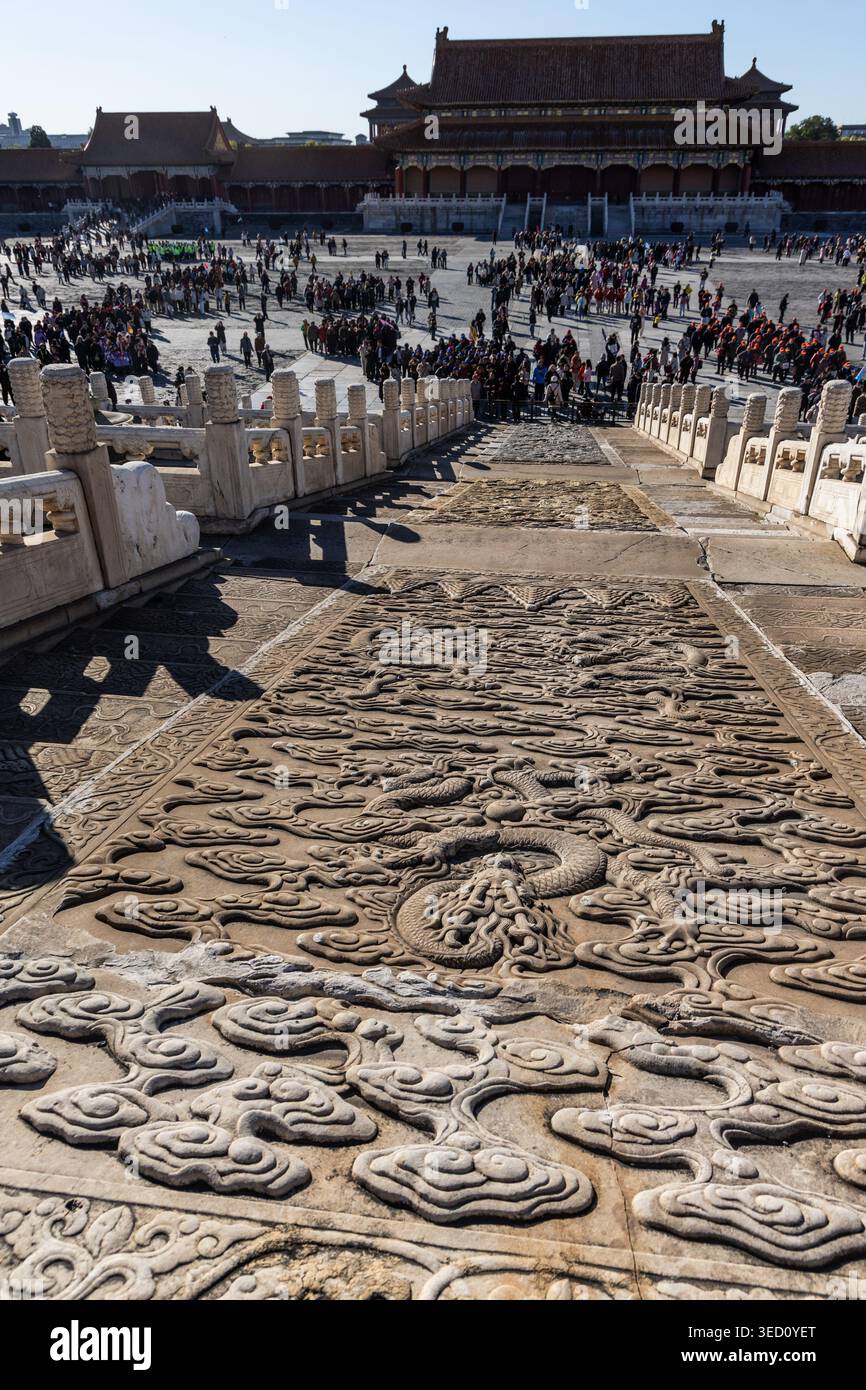 La folla sfocata e irriconoscibile che ammira il percorso del Drago nella città Proibita è il sentiero centrale in pietra sopraelevata che conduce alle sale principali. Foto Stock