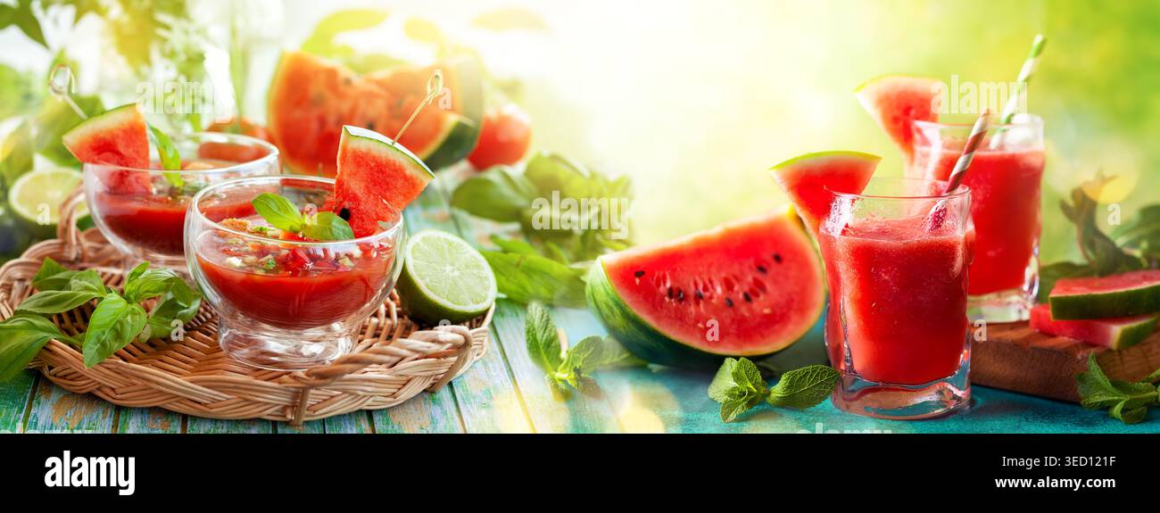 Bevande all'anguria rinfrescanti in estate in bicchieri e gazpacho a zuppa fredda con basilico su un tavolo di legno. Concetto di sana alimentazione estiva. Foto Stock