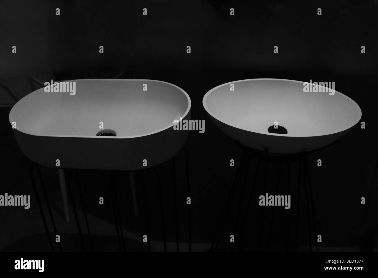 Le camere oscurate sottolineano il design pulito e moderno del bagno. I lavandini circolari offrono uno stile contemporaneo per qualsiasi spazio Foto Stock