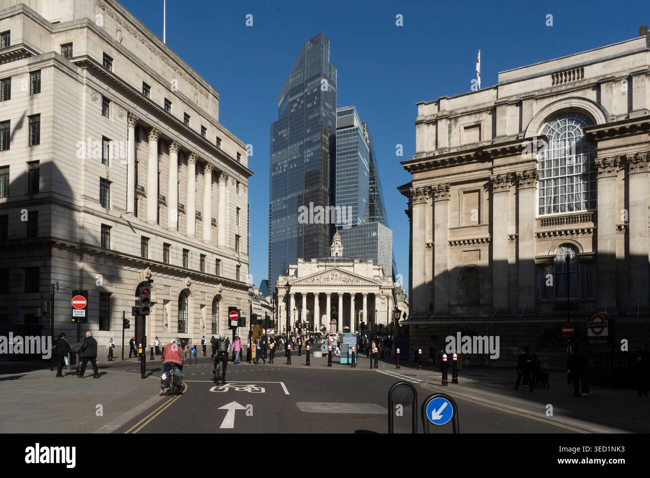 La gente passa davanti alla Bank Junction e ai moderni grattacieli del quartiere finanziario della City of London. Foto Stock