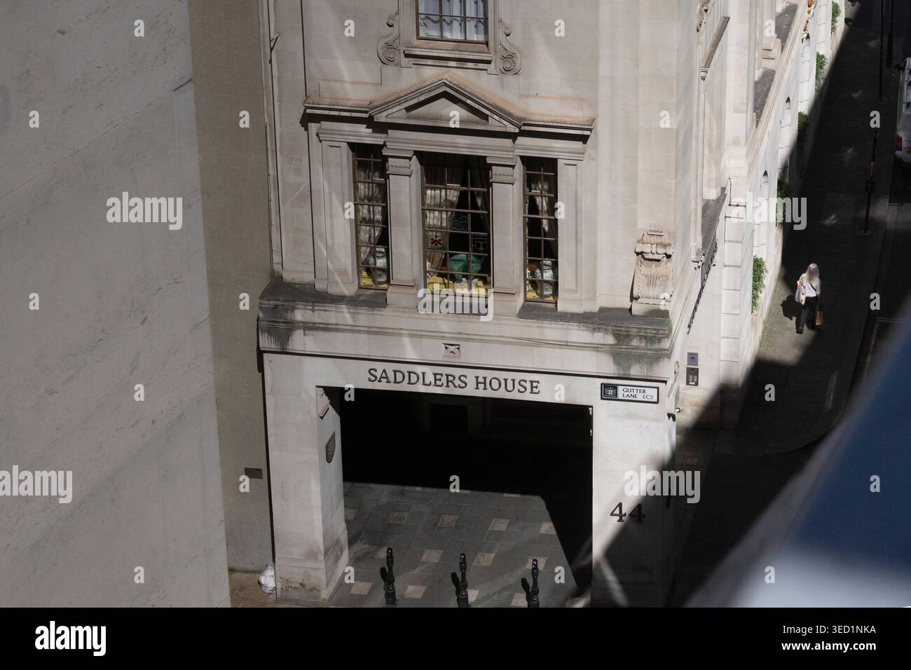 Una donna passa davanti a Saddlers House a Gutter Lane, EC2, Londra Foto Stock