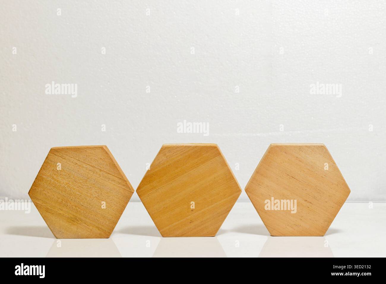 Tre blocchi esagonali in legno su sfondo bianco. Forma geometrica. Blocco di legno. elemento in legno. Foto di alta qualità Foto Stock