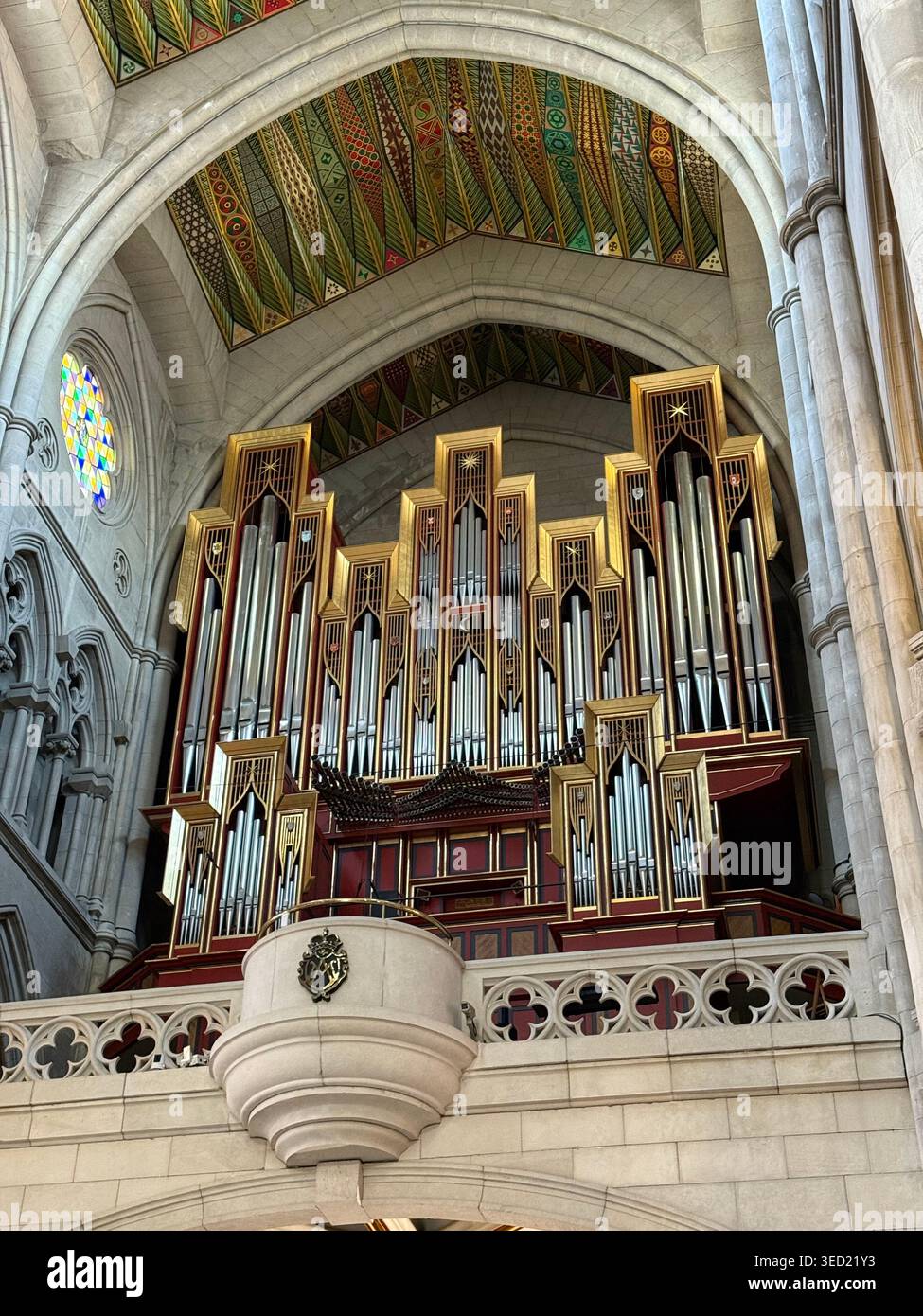 Vista interna dell'organo a canne sotto un arco a mosaico decorato all'interno della Catedral de Santa María la Real de la Almudena a Madrid, Spagna. - Immagine stock catturata con smartphone