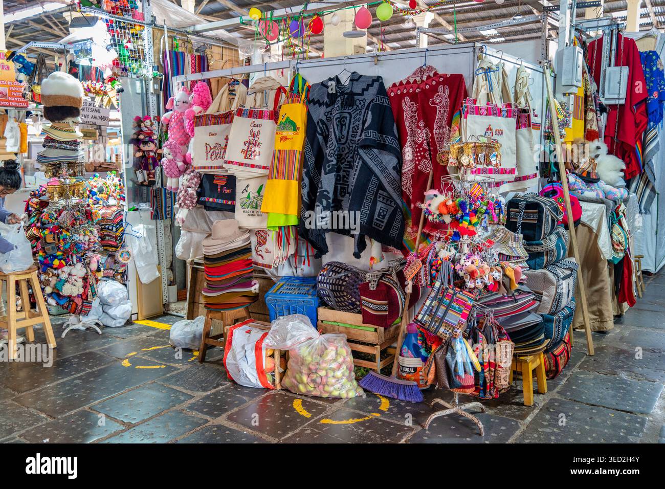 Cusco, Perù - 23 marzo 2025: Stand di souvenir con artigianato tradizionale andino, tra cui poncho intrecciati, borse tote colorate e cappelli fatti a mano al San Foto Stock