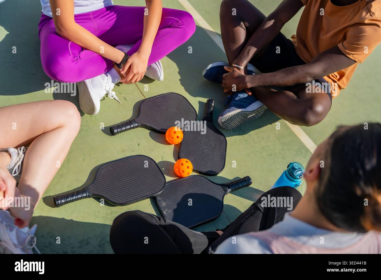 Gruppi di amici diversi seduti su un campo da baseball Foto Stock