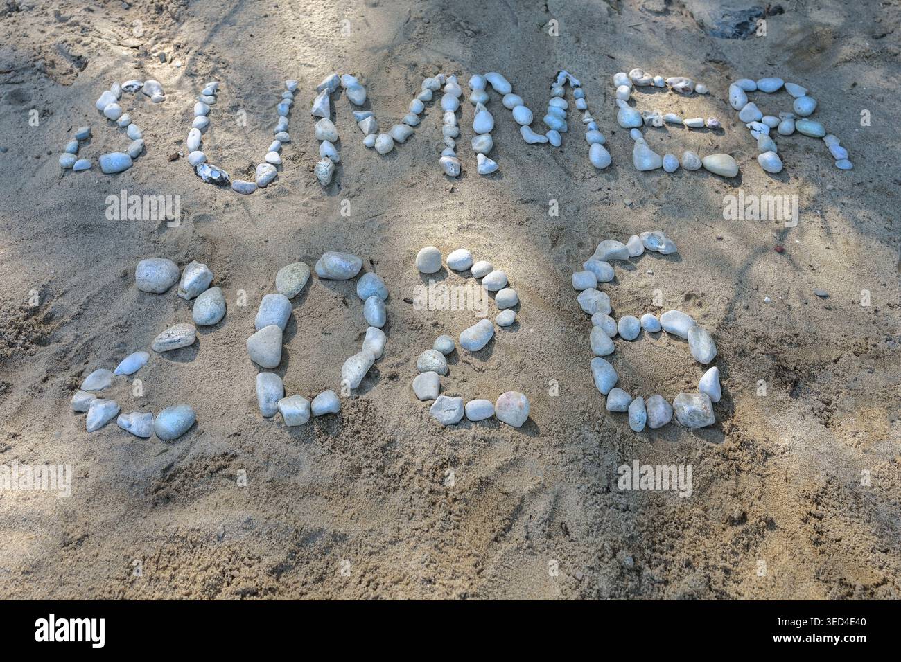 Estate 2026, il testo è scritto con ciottoli sulla sabbia sulla spiaggia, simbolo per il tempo libero, le vacanze al mare e il sole caldo, copia spazio, selezionato Foto Stock