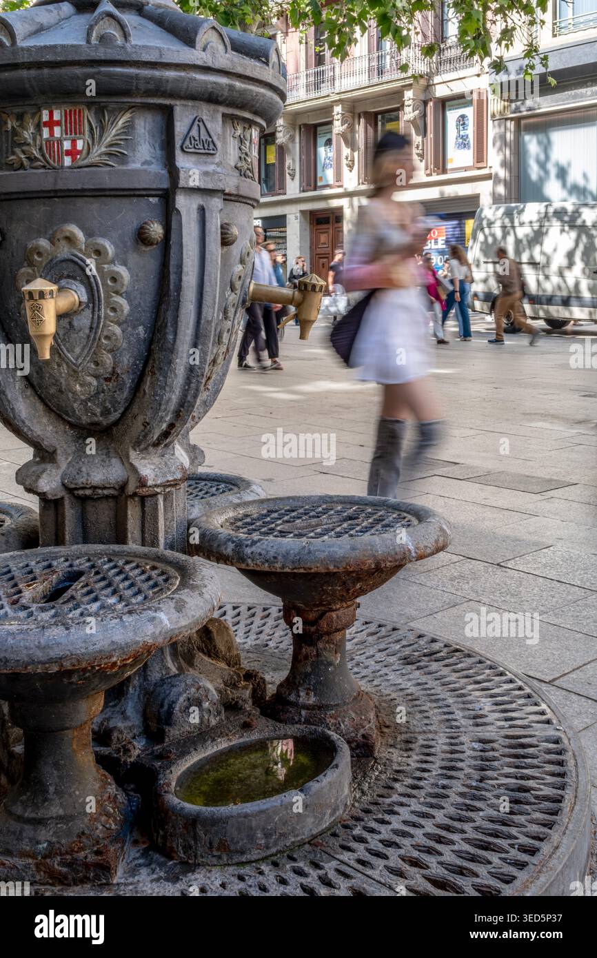 Wallace Fountain, storica fontana del ferro con cariatidi, persone che camminano con Motion Blur, Barcellona Foto Stock