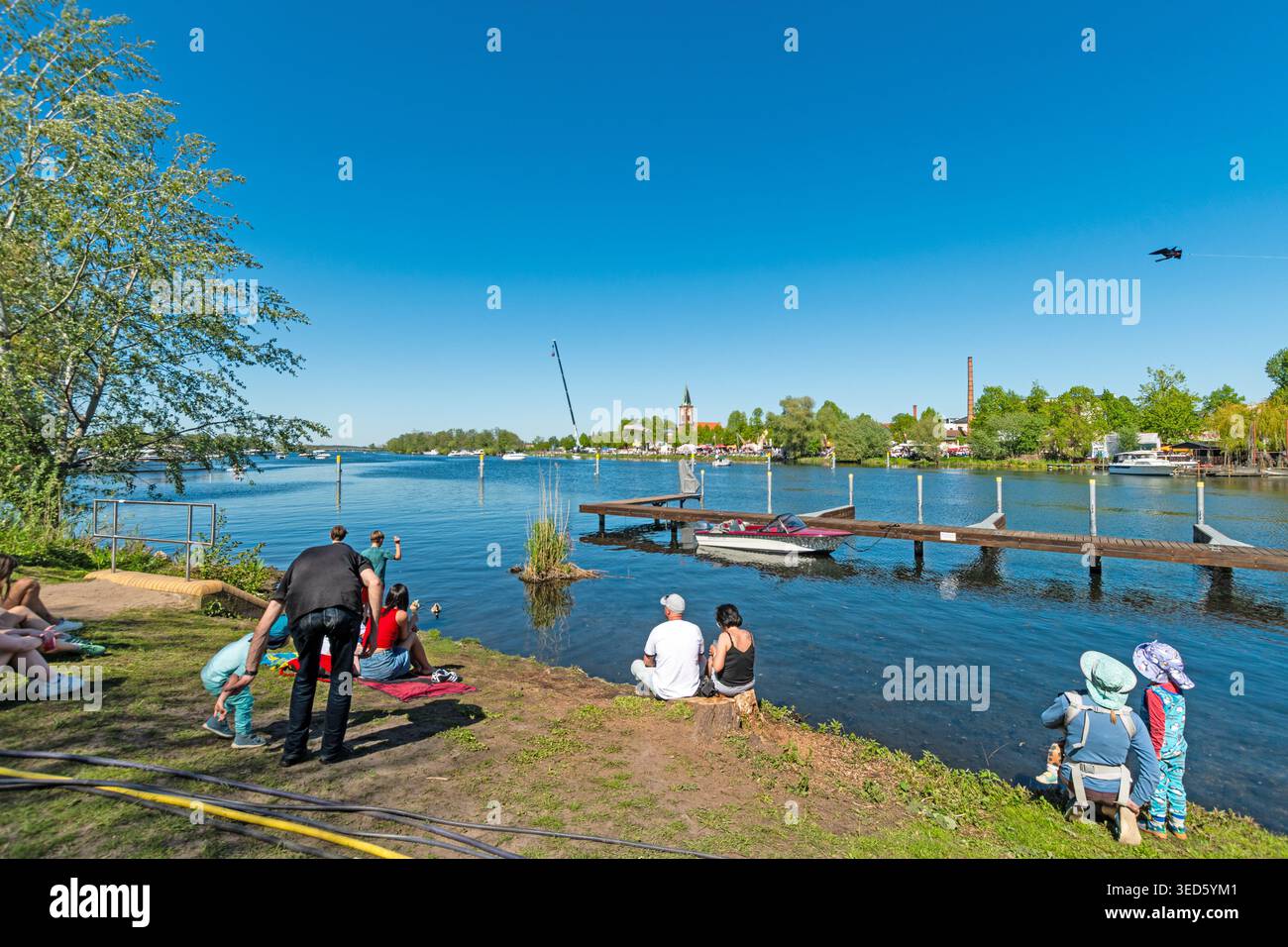 Werder (Havel), Brandeburgo, Germania, 2 maggio 2026: Persone che si rilassano e trascorrono del tempo libero lungo la riva del fiume con barche e paesaggi della città nella ba Foto Stock