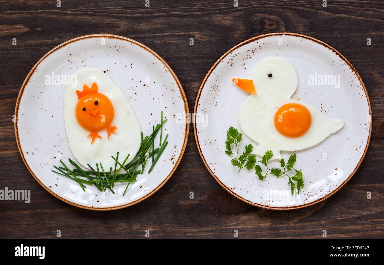 Colazione di Pasqua per i bambini con uova fritte sagomate su un piatto Foto Stock
