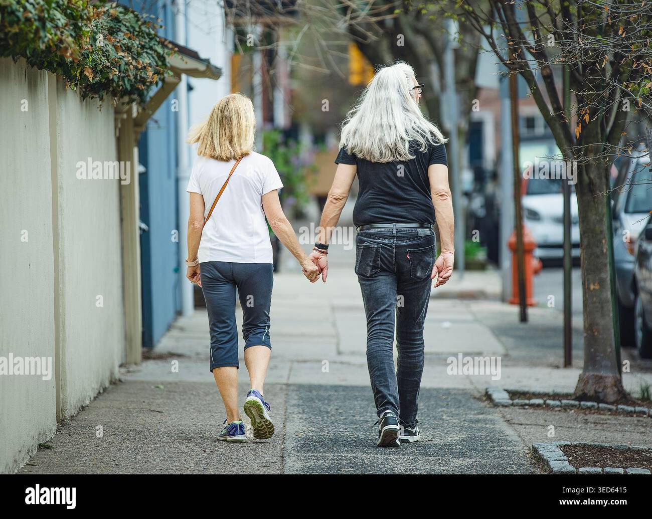 Una coppia di mezza età cammina mano nella mano Foto Stock