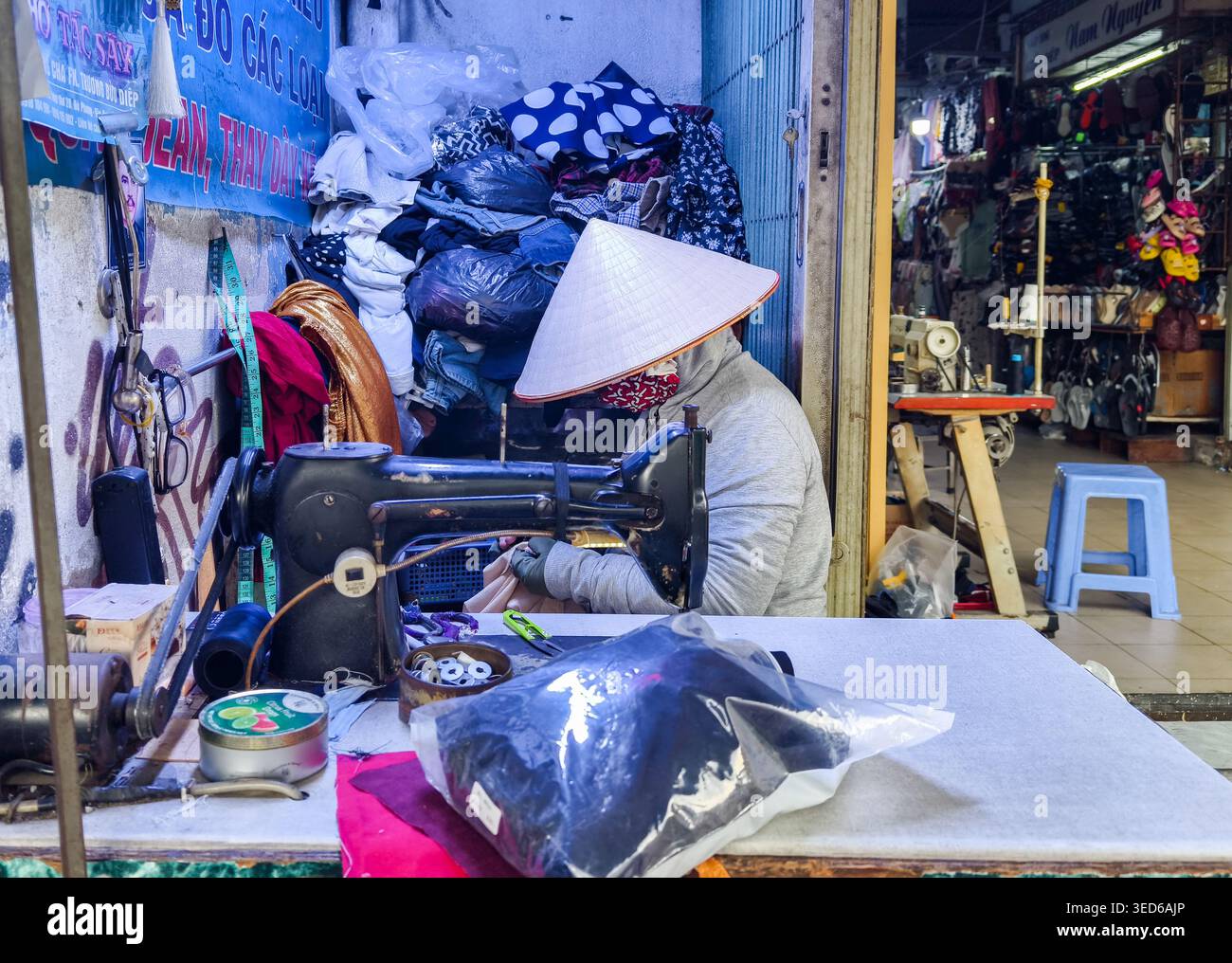 Tradizionale sarto vietnamita di strada, tipicamente visto nei mercati o nelle piccole bancarelle, che lavora diligentemente su una macchina da cucire, ho chi Minh City, Vietnam Foto Stock