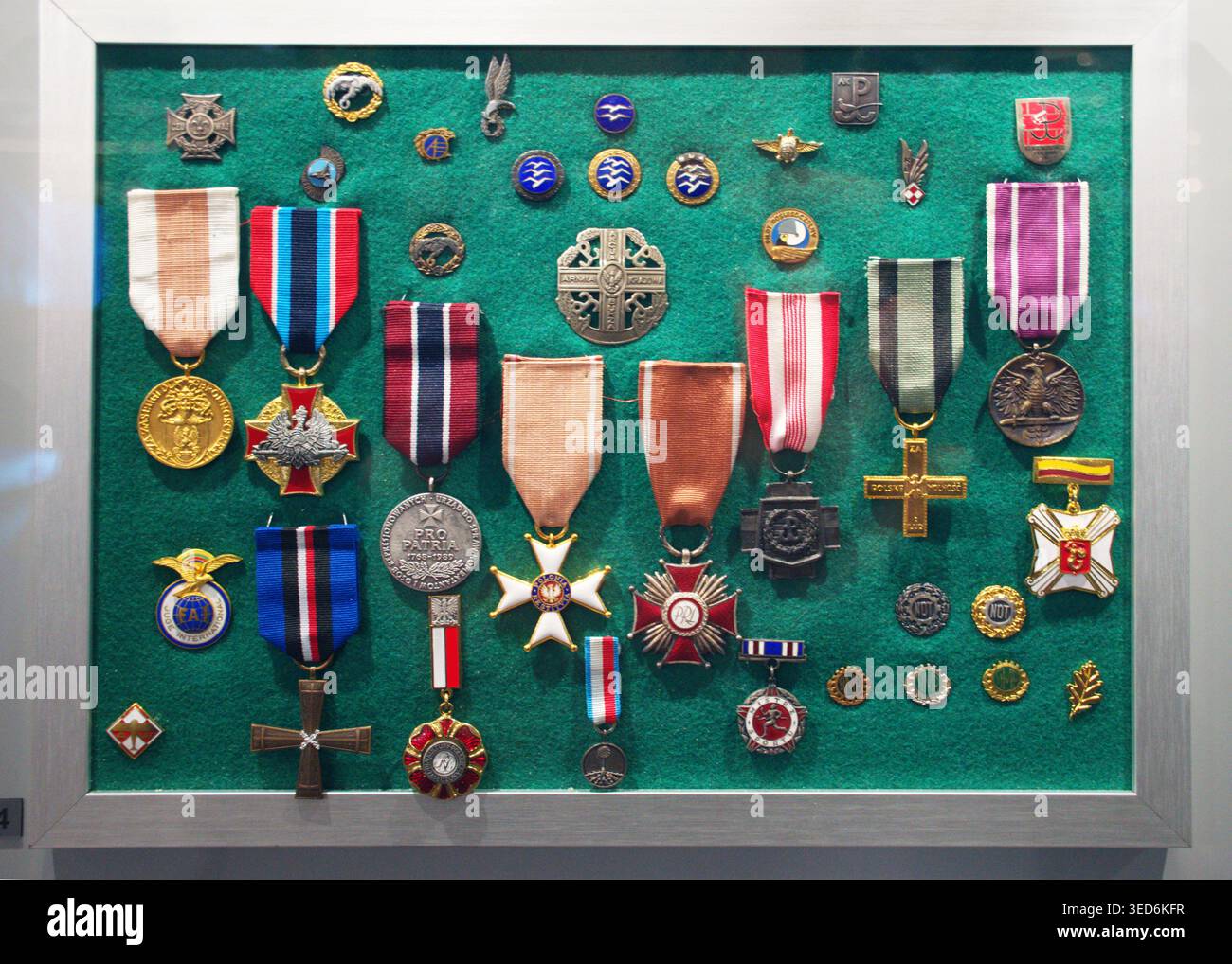 Cracovia, Polonia - 4 maggio 2026: Collezione di medaglie militari, nastri, spille e decorazioni esposte in un museo con sfondo in tessuto verde. Foto Stock