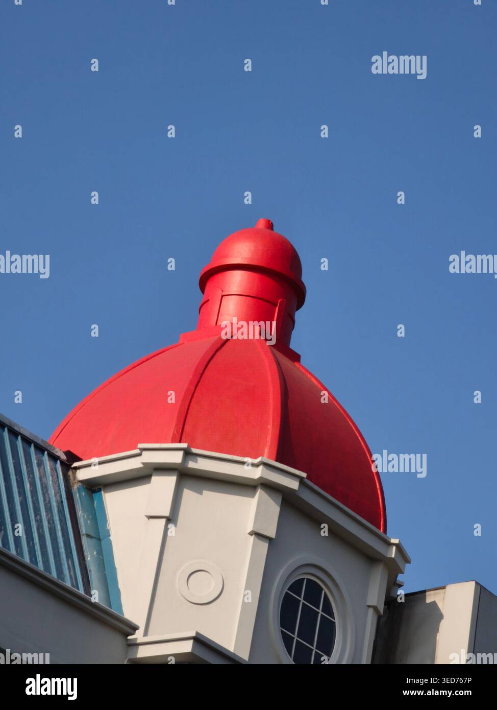 Da vicino la cupola rossa di un suggestivo edificio moderno che si erge sotto il cielo azzurro e presenta linee architettoniche pulite e un elegante design di stile europeo Foto Stock
