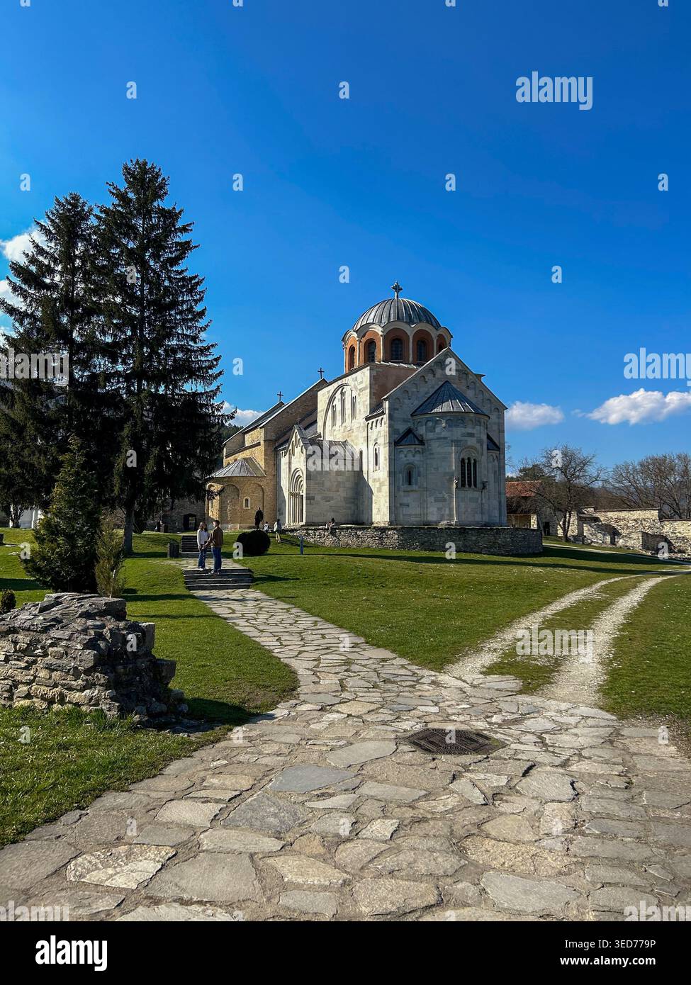 Chiesa del Monastero di Studenica in Serbia con facciata in marmo bianco e cupole sotto il cielo azzurro, che mostrano l'architettura medievale ortodossa. - Immagine stock catturata con smartphone