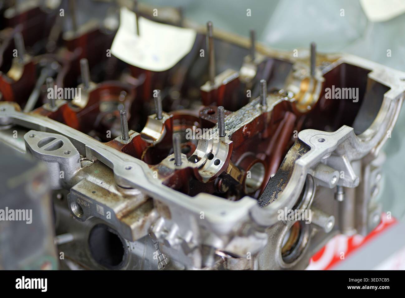 Una testata del motore parzialmente smontata mostra le sedi dei cuscinetti dell'albero a camme, i prigionieri e i condotti dell'olio, con indicazione visibile dei residui di olio. Foto Stock