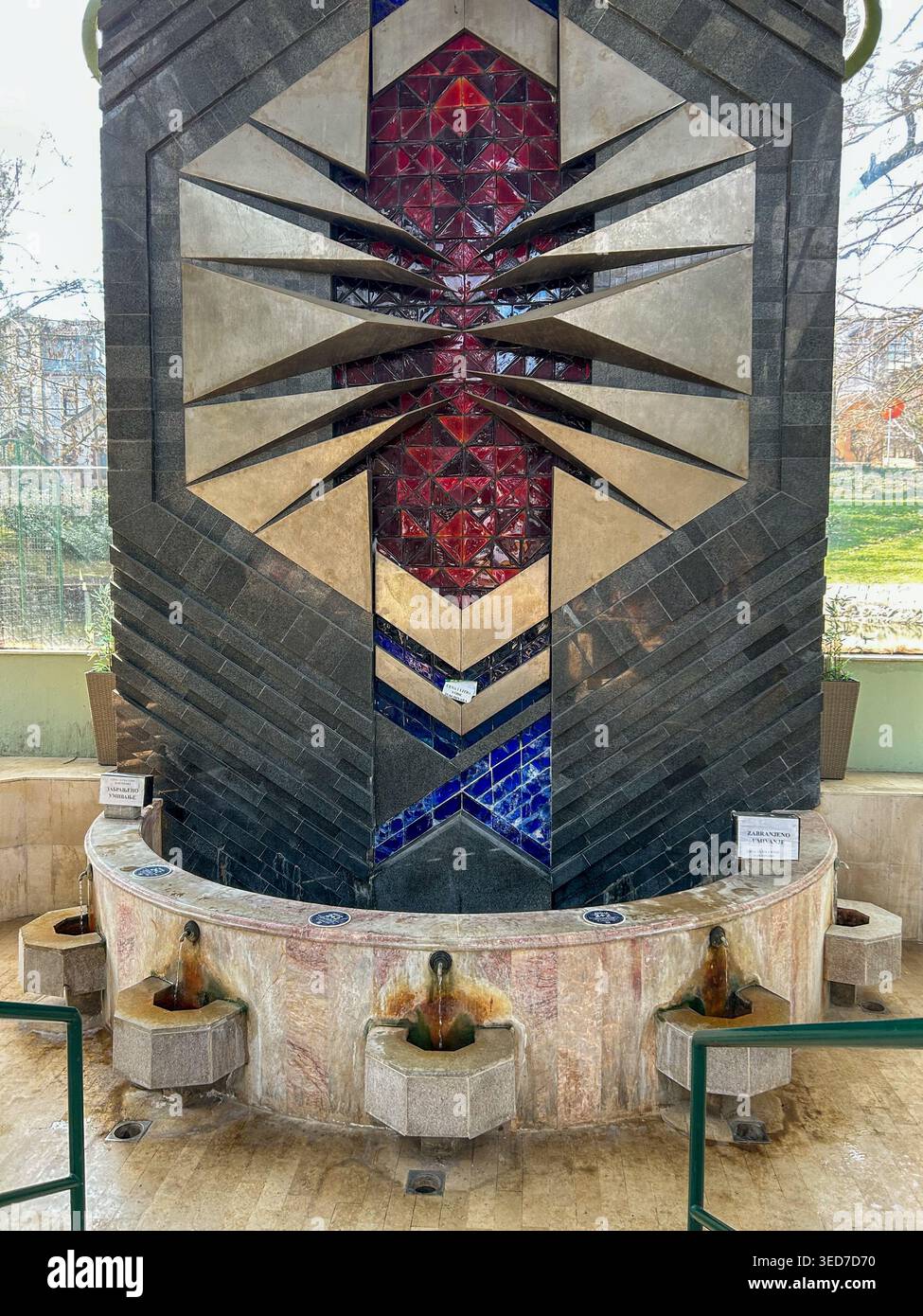 Fontana minerale Jezero a Vrnjačka Banja, Serbia, con pietra decorativa e acqua termale fluente. - Immagine stock catturata con smartphone