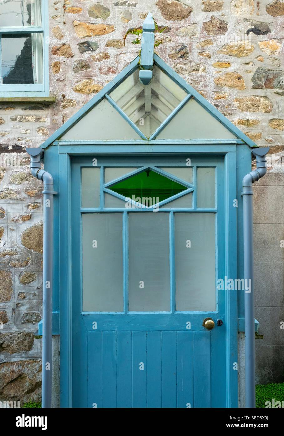 Un portico in legno e vetro per tempesta dipinge di blu con un triangolo di vetro verde a Mousehole, Cornovaglia Foto Stock