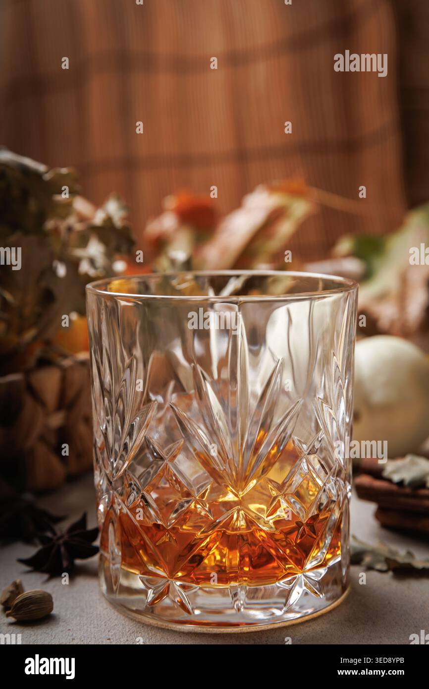 Bicchiere di whisky del giorno del Ringraziamento su sfondo rustico con foglie. Foto Stock