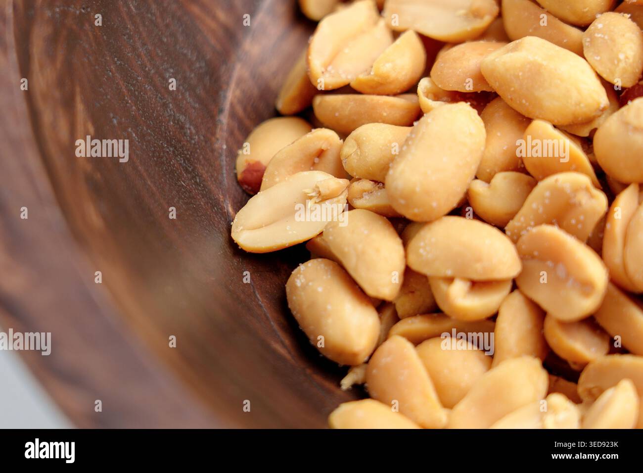Arachidi salate arrostite in un recipiente rustico di legno. Vista dall'alto. Foto Stock