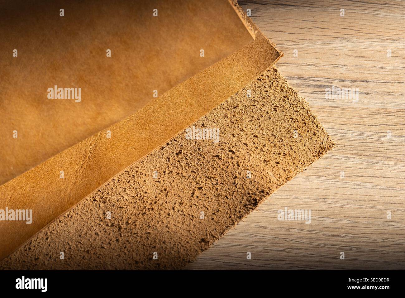 Due strati di fogli in pelle naturale marrone chiaro su superficie in legno, primo piano in materia prima Foto Stock
