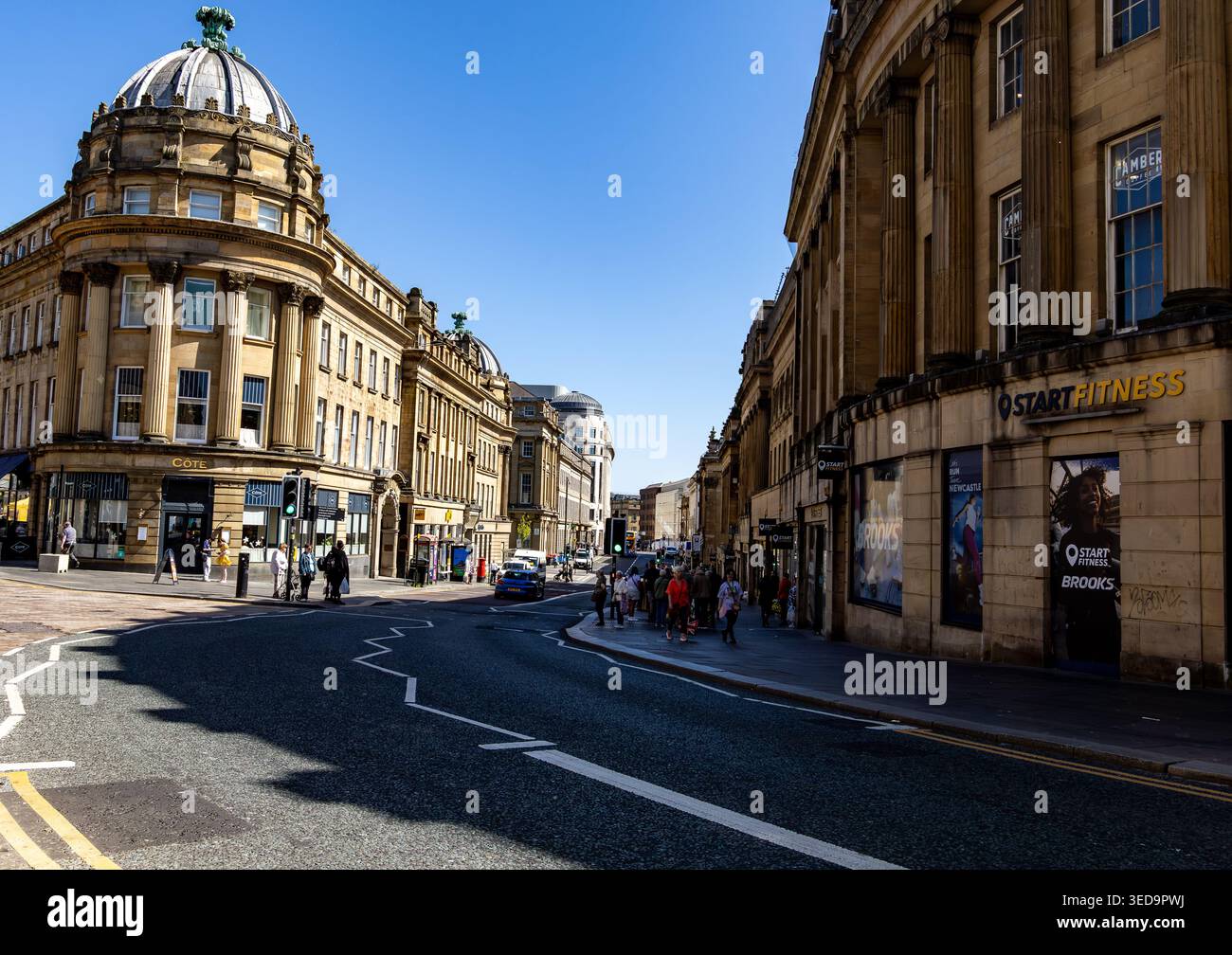 La storica strada di Newcastle upon Tyne presenta un'architettura classica, pedoni e negozi in una giornata di sole Foto Stock