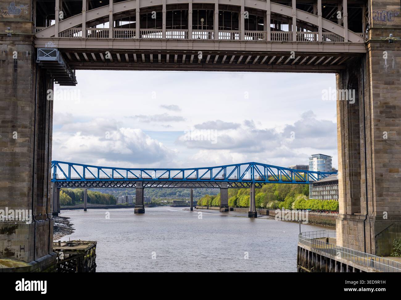 Veduta del Ponte della Regina Elisabetta II a Newcastle upon Tyne incorniciata dalla massiccia struttura in pietra del ponte ferroviario ad alto livello Tyne Foto Stock