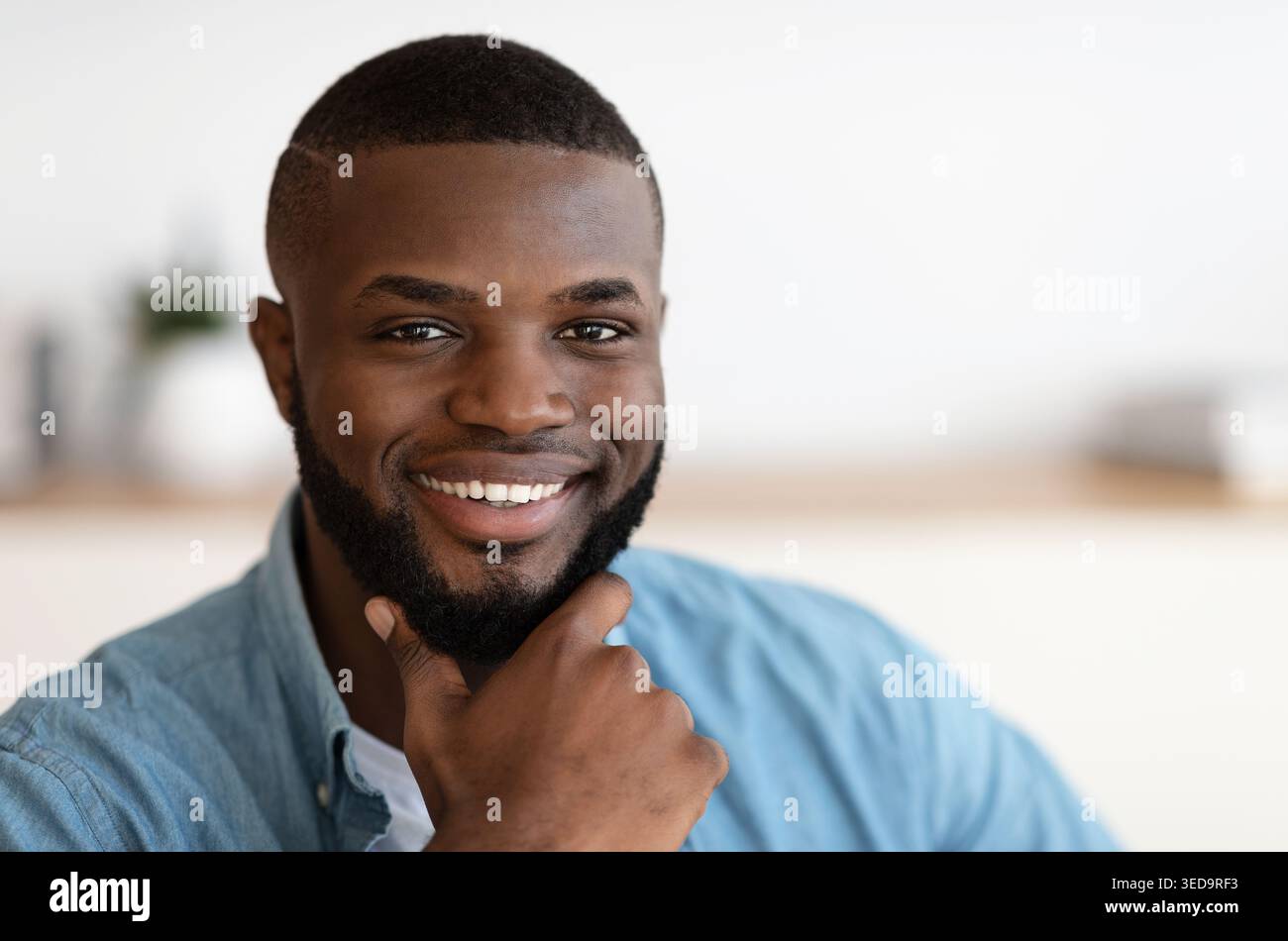 Ritratto closeup di bella sorridente afroamericana che tocca la barba Foto Stock