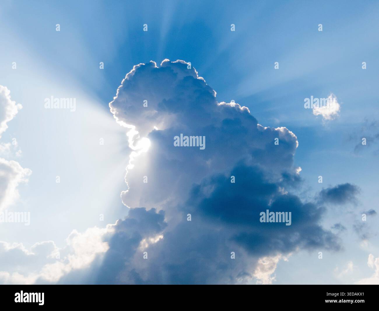Il sole esce da dietro il paesaggio delle nuvole Foto Stock