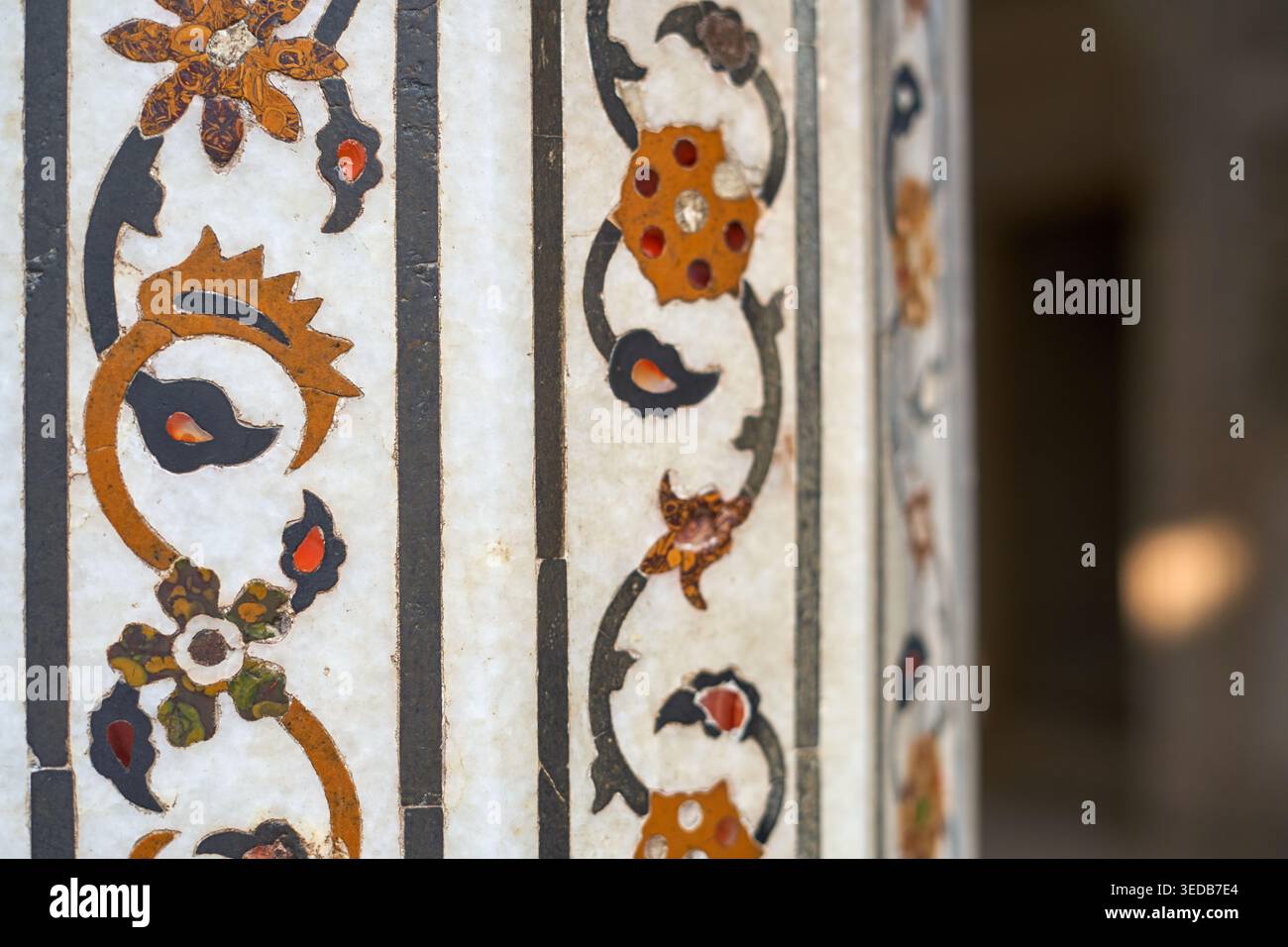 Fotografia in primo piano che mostra intricate lavorazioni decorative in pietra dura (intarsi di pietra dura) su marmo bianco, caratteristiche dell'architettura Mughal in Foto Stock