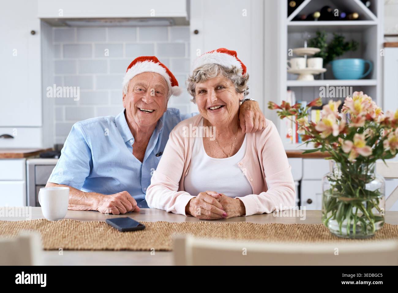Natale, ritratto e coppia senior in casa, sorriso e legame con le feste. Cappelli natalizi, vecchio e donna in cucina, amore e.. Foto Stock
