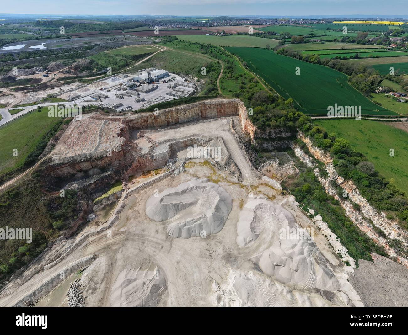 Vista aerea della cava Marshalls Maltby con pozzi di estrazione di calcare, grandi pali di sabbia e impianti industriali circondati da verdi campi a Maltb Foto Stock