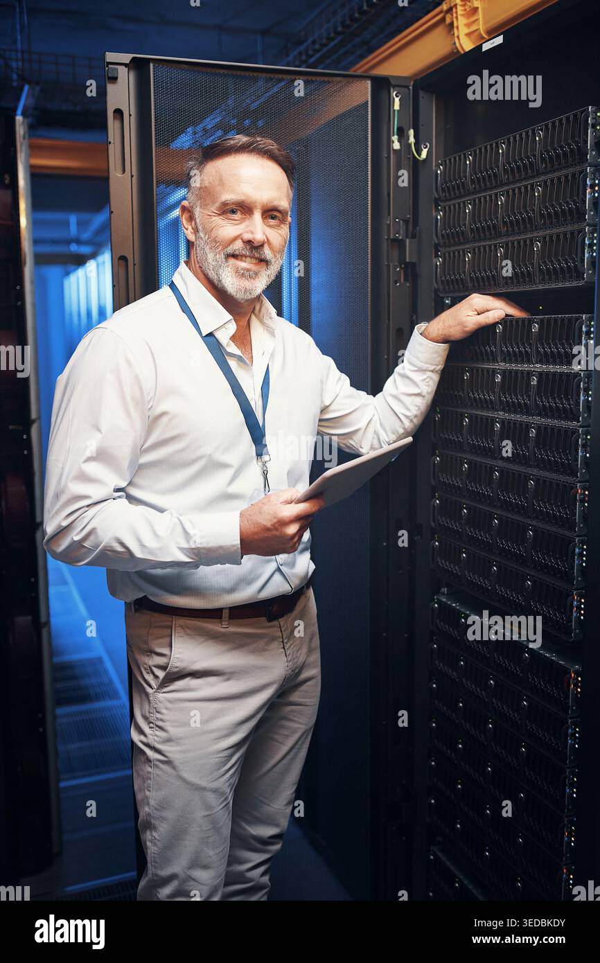 Hardware, tecnico e ritratto con tablet nella sala server per l'ispezione dei rack, il supporto IT o Happy. Data center, uomo maturo e tecnologia per la rete Foto Stock