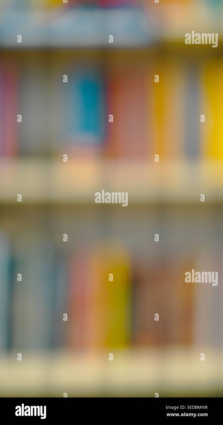 Sfondo astratto sfocato di colonne colorate disposte sugli scaffali della biblioteca. Foto Stock