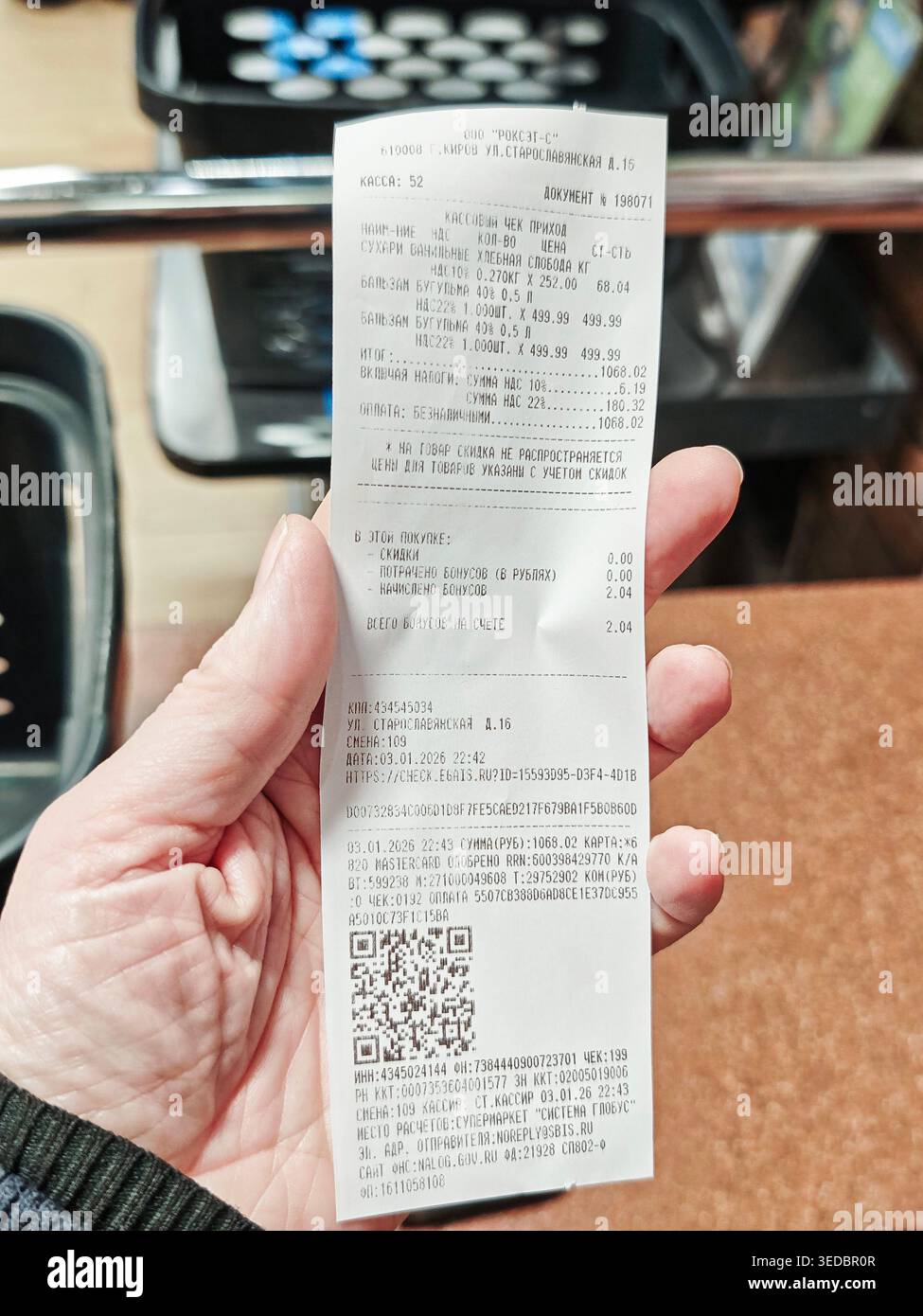 Kirov, Russia - 3 gennaio 2026: Consegna a mano una ricevuta di un negozio di alimentari che riporta i dettagli degli acquisti e conferma il pagamento degli articoli acquistati durante uno shopping Foto Stock