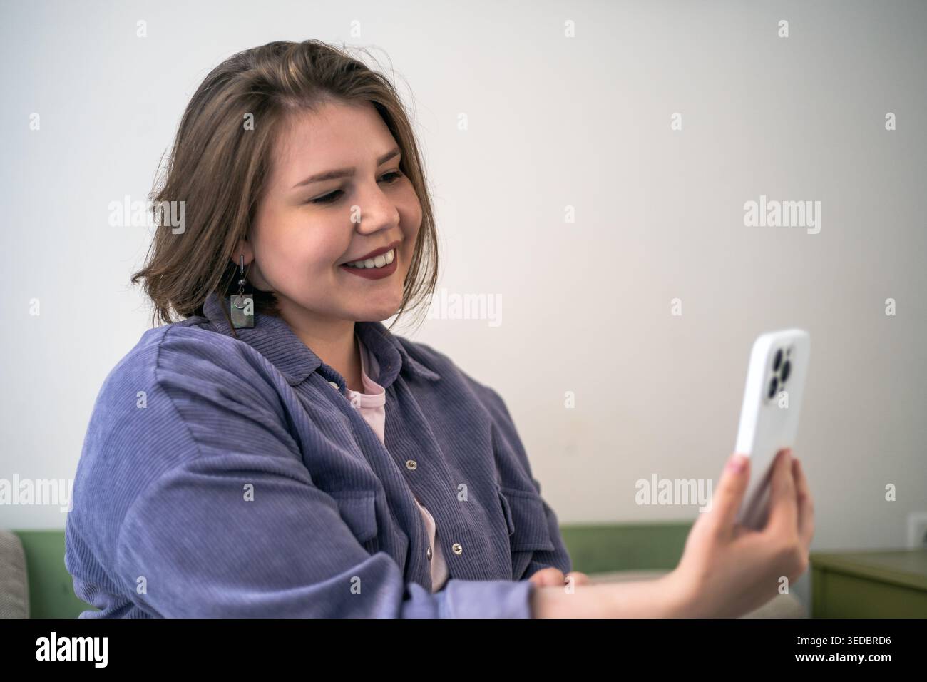 Videochiamata e donna che sorride con lo smartphone, amicizia online, incontri virtuali, connessione mobile, fiducia autentica, stile di vita domestico. Foto Stock