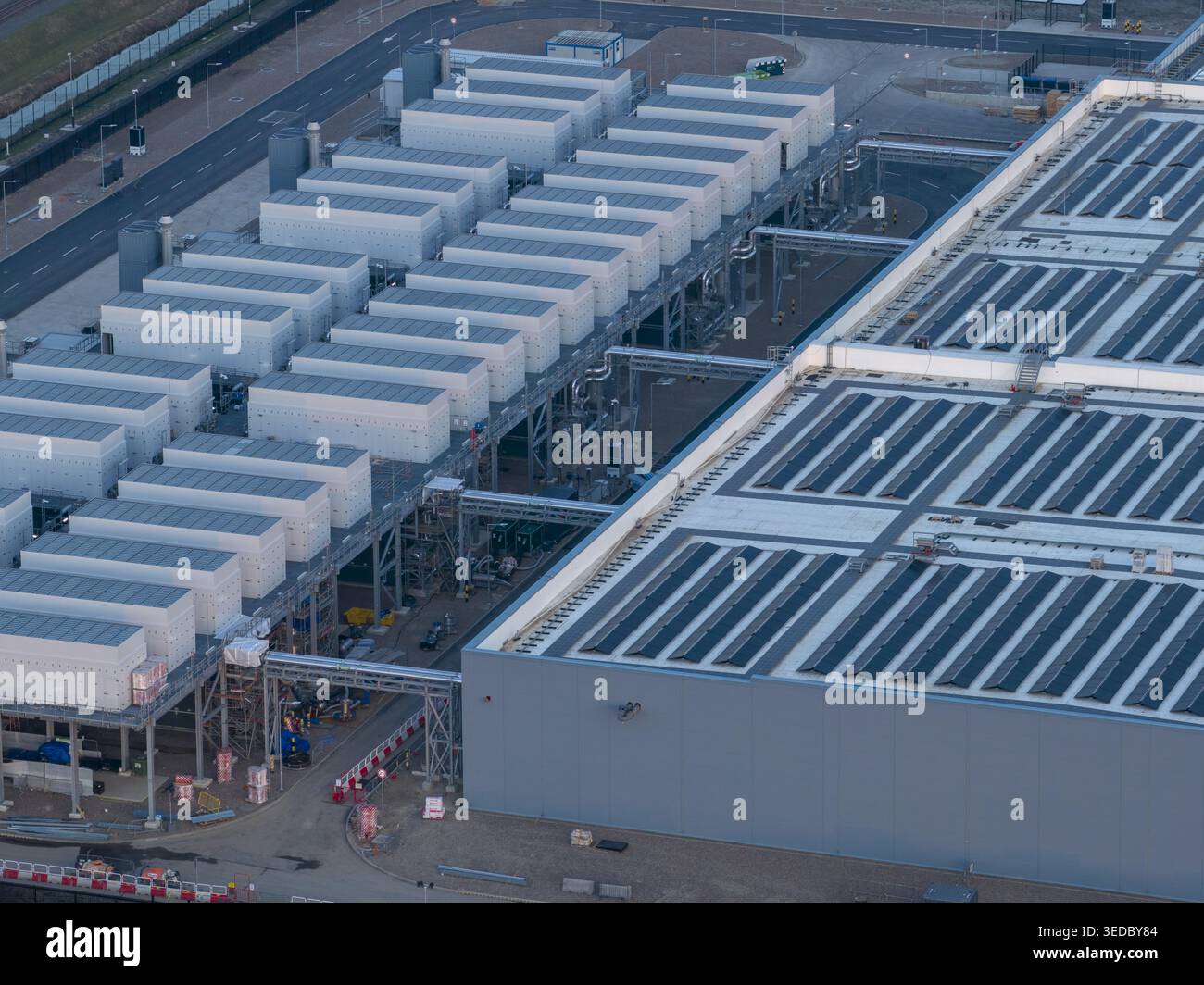 Vista aerea di una struttura di data center iperscala con file di unità di raffreddamento industriali e infrastrutture complesse. Foto Stock