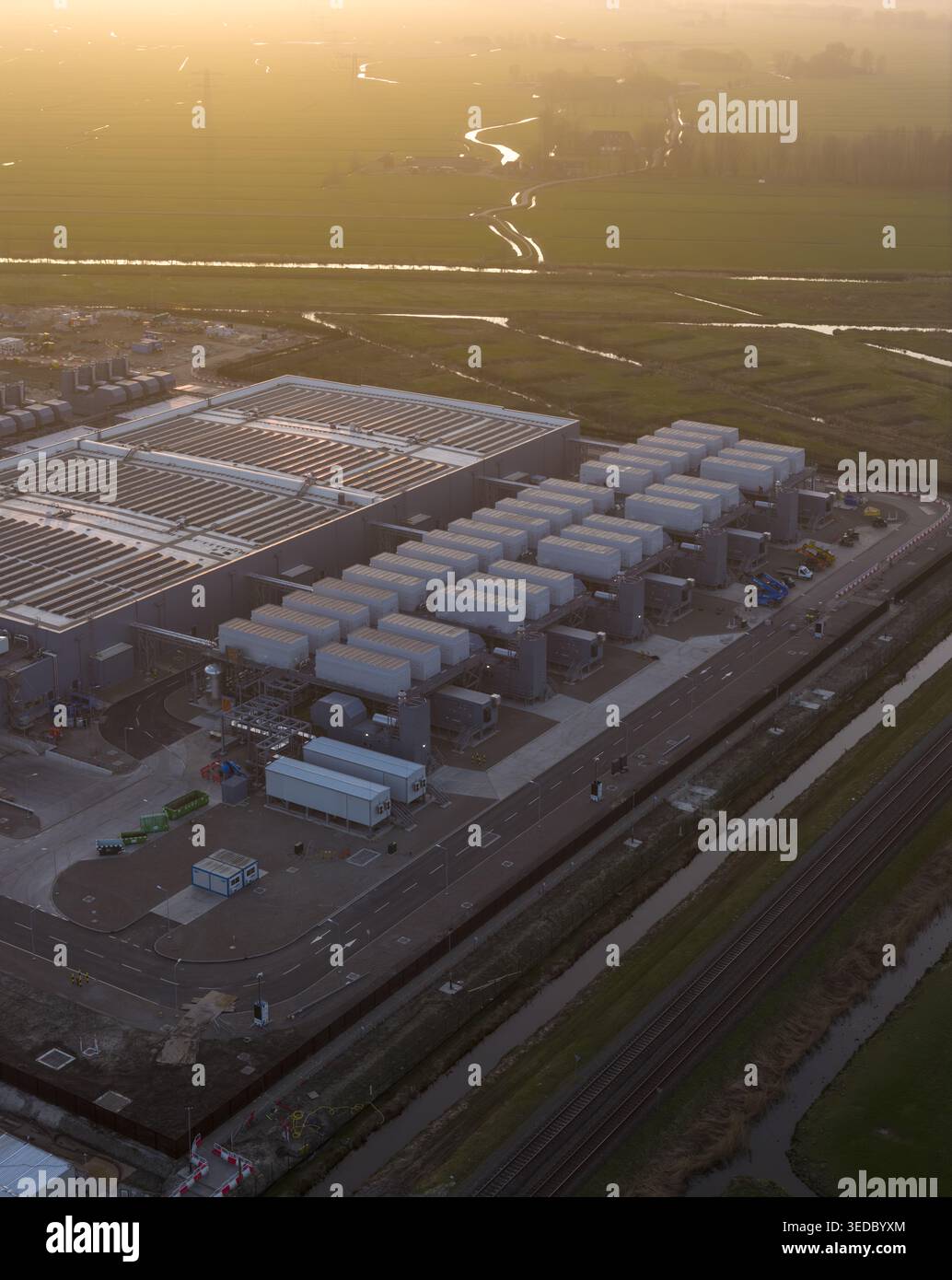 Vista aerea della struttura del data center di Google con unità di raffreddamento e infrastrutture industriali vicino a campi verdi e binari ferroviari durante un gol Foto Stock