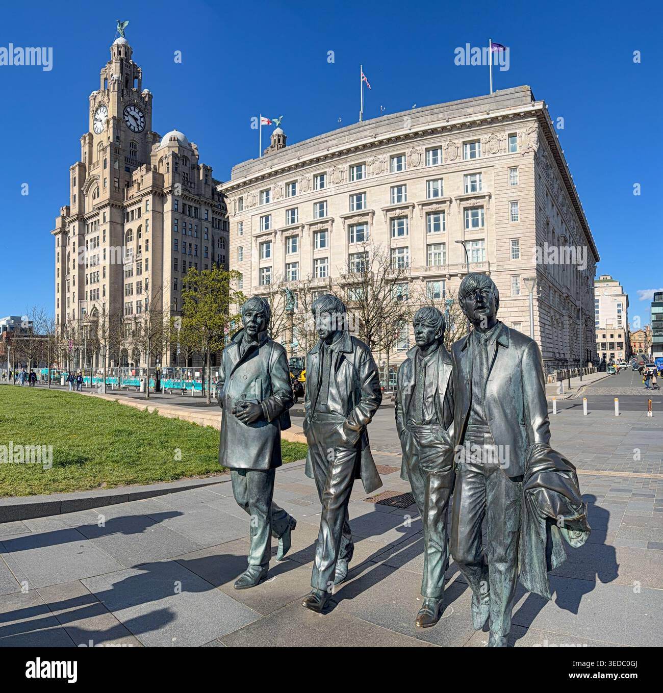 LIVERPOOL, MERSEYSIDE, INGHILTERRA - 19 APRILE 2026: Le statue in bronzo dei Beatles si trovano a Pier Head, con l'iconico Royal Liver Building - Immagine stock catturata con smartphone
